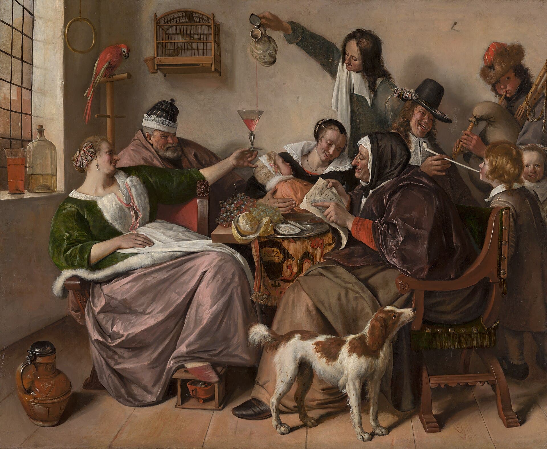A boisterous household around a table: a grandmother sings from a songsheet, a father raises a glass toward a laughing child, and a small boy is being handed a pipe to smoke.
